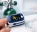 A pulse oximeter displaying oxygen saturation and pulse rate on a finger