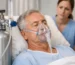 Hospital patient being monitored by a nurse while on oxygen