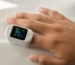 A close-up of a fingertip pulse oximeter displaying oxygen saturation and heart rate
