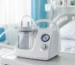 A hospital bed alongside a suction machine, representing essential medical equipment for respiratory support